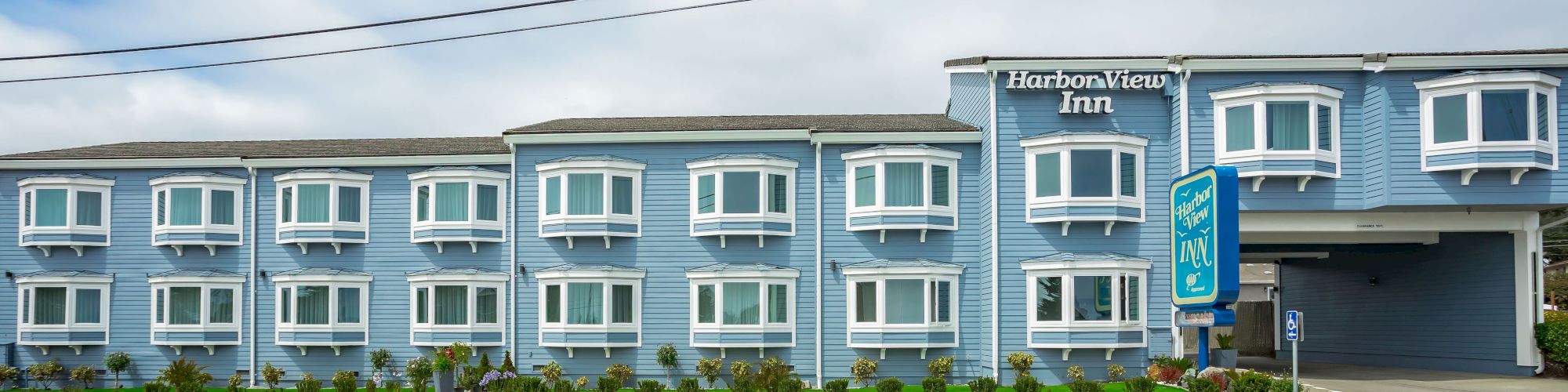 A light blue two-story building with multiple white-framed windows and a 